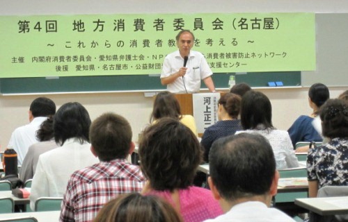 横断幕「第4回地方消費者委員会（名古屋）」を背に講演する委員長の写真