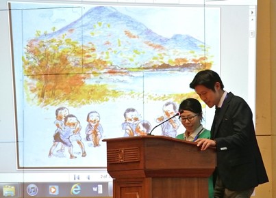 XXXX Kondo, Deputy Director of JICA’s Human Development Department (right), and XXXX Komatsu, staff member of the International Committee on MCH Handbook (left) present the life of Dr. Noguchi as a picture-story show.