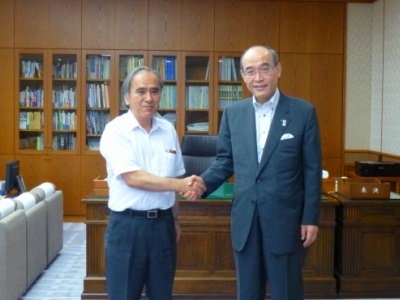 谷本正憲知事と河上委員長が握手している写真
