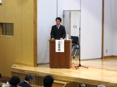 シンポジウムの司会進行する小田審議官の写真