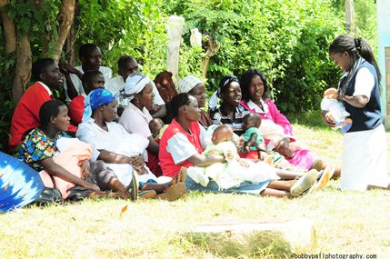 村の母親たちに授乳方法を指導する看護師（ケニア）