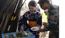 他国の部隊との交流のため、浴衣姿で料理を装う女性自衛官の様子