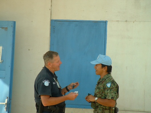 2002年、UNMISETにて他国文民警察要員と会話する川村補佐(右側）のimg